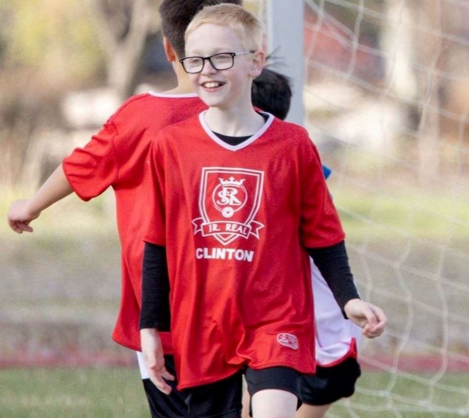 A child smiling playing soccer