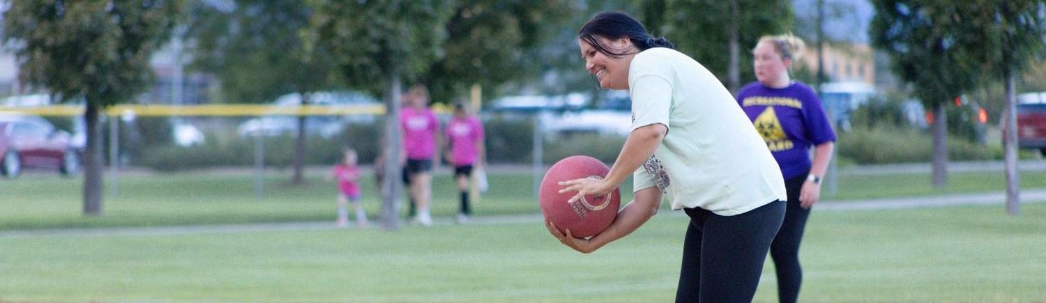 A kickball player pitching the ball